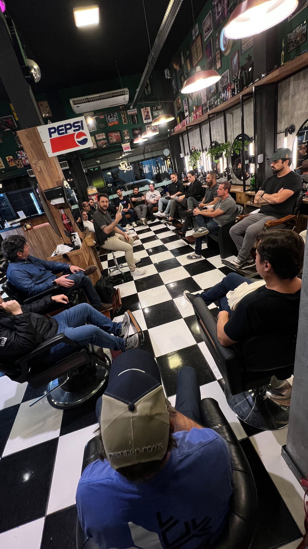 Homens reunidos em um encontro da Confraria de Deus na barbearia